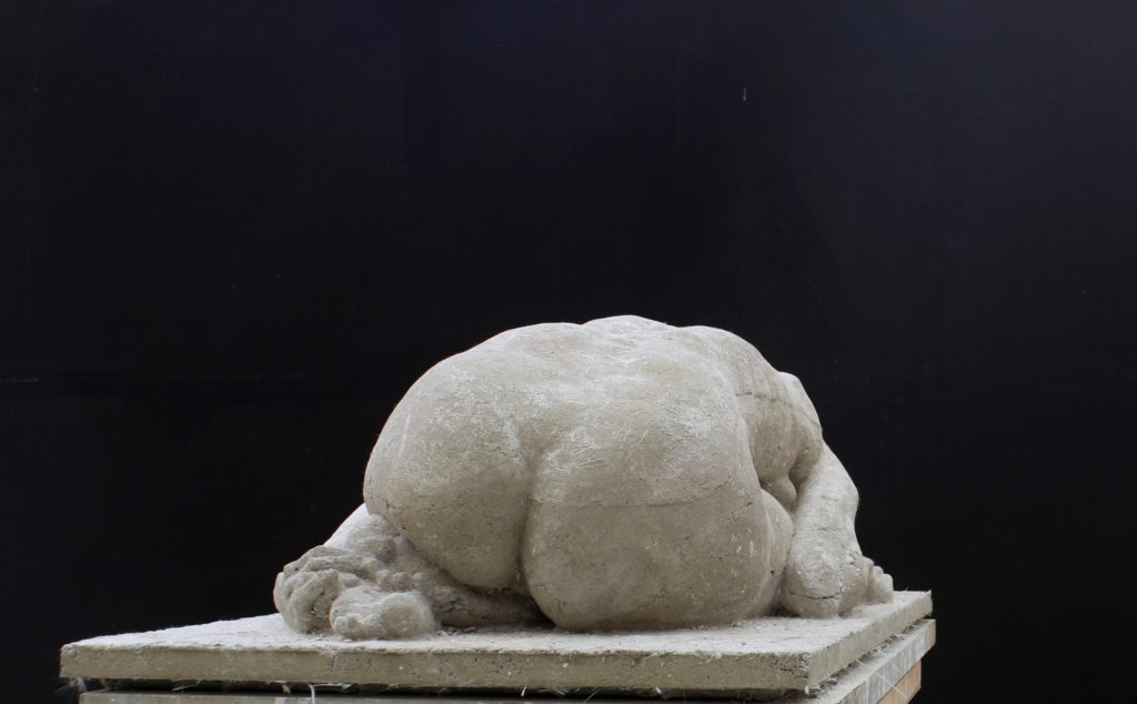 rzeźba skulonej kobiety z betonu