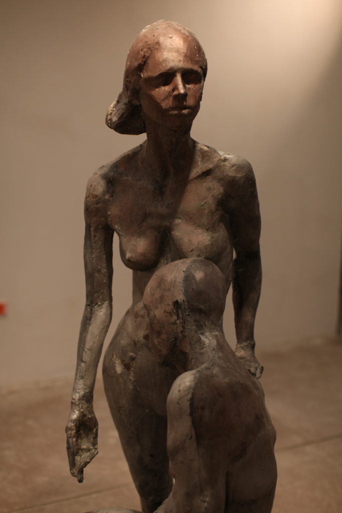 rzeźba mężczyzny opartego w pozycji siedzącej o stojącą kobietę